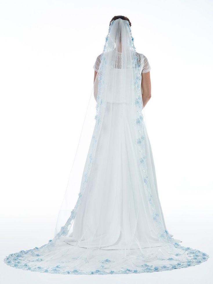 the back of a bride's wedding dress, with blue flowers on her veil