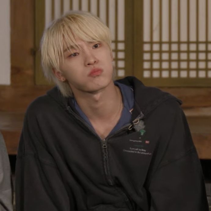 a young man with blonde hair sitting down