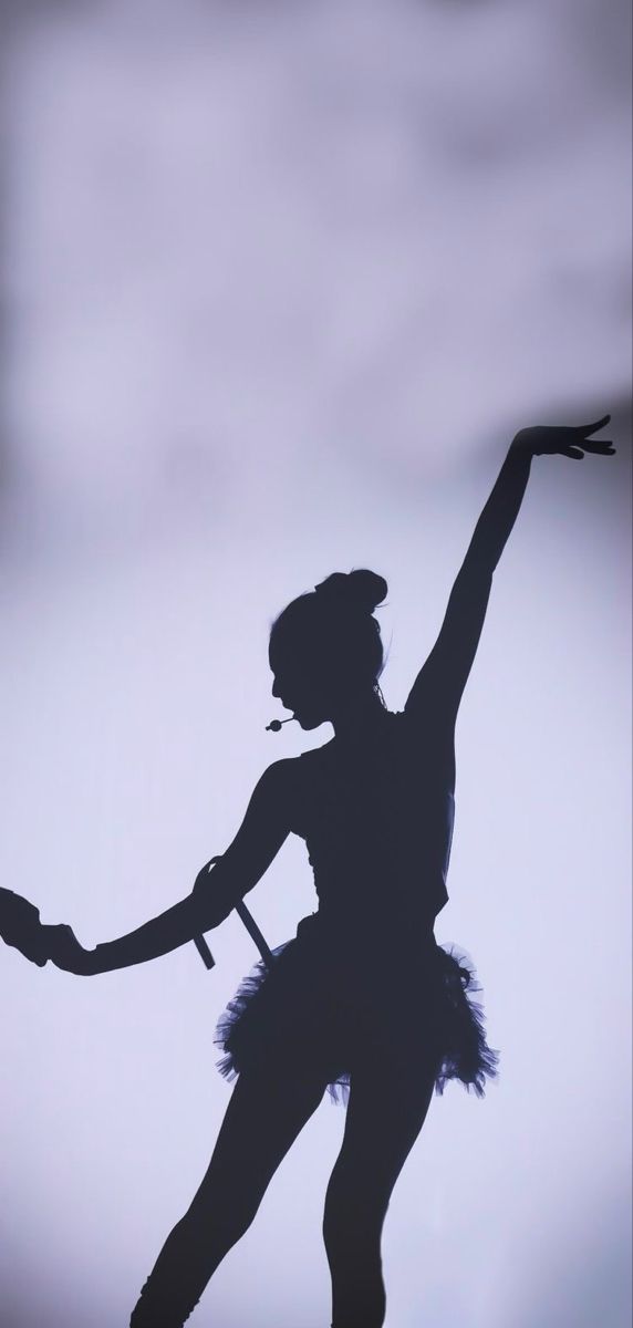 the silhouette of a woman in a tutu dancing