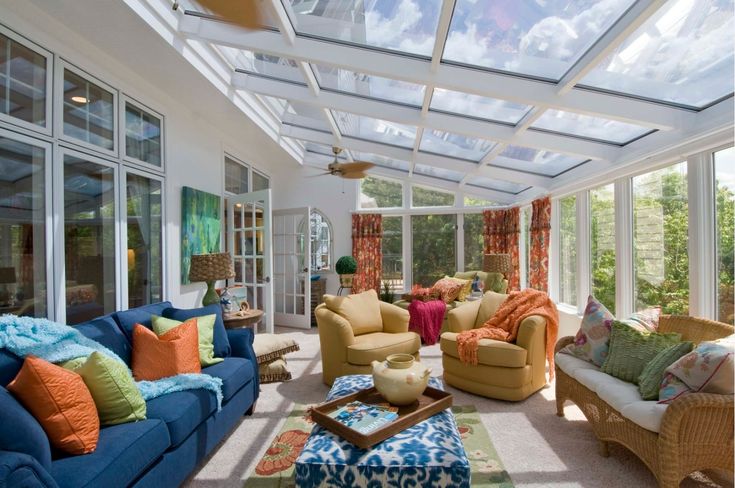 a living room filled with lots of furniture under a glass ceiling covered in skylights