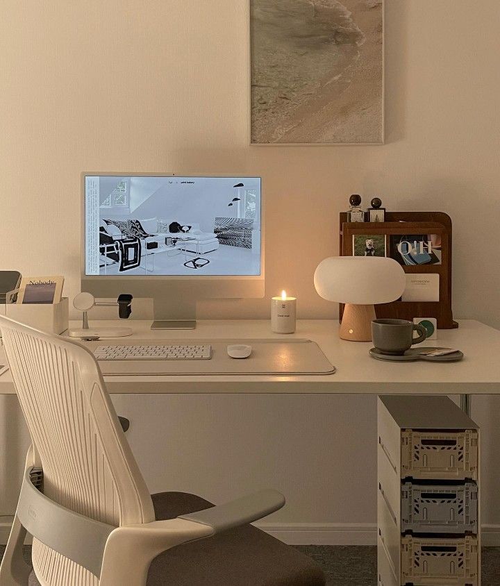 a white desk with a computer on it and a chair in front of the monitor