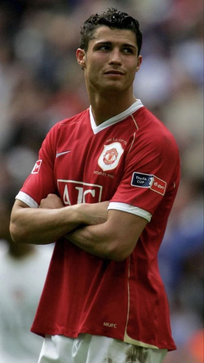 a soccer player is standing with his arms crossed