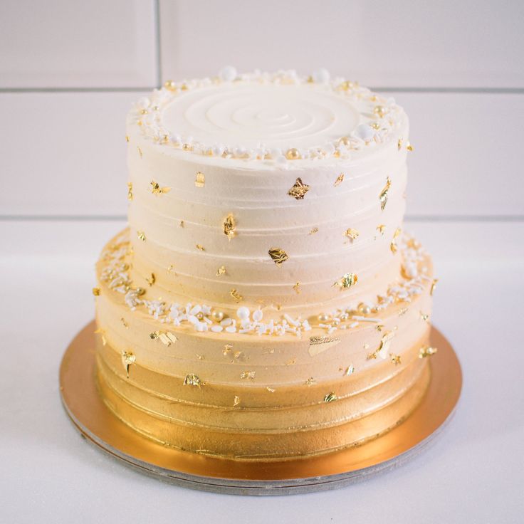 a three layer white cake with gold sprinkles