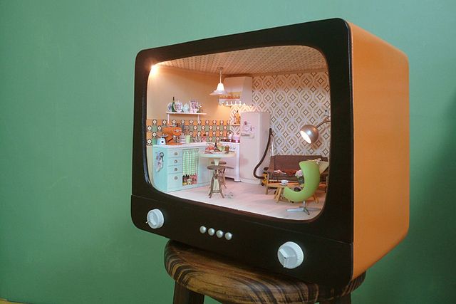 an old fashioned television sitting on top of a wooden stool