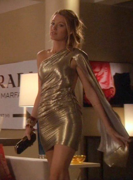 a woman is walking down the runway in a gold dress with one hand on her hip