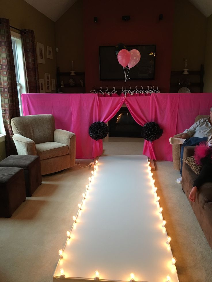 a living room filled with lots of furniture and lights on the floor in front of a fireplace