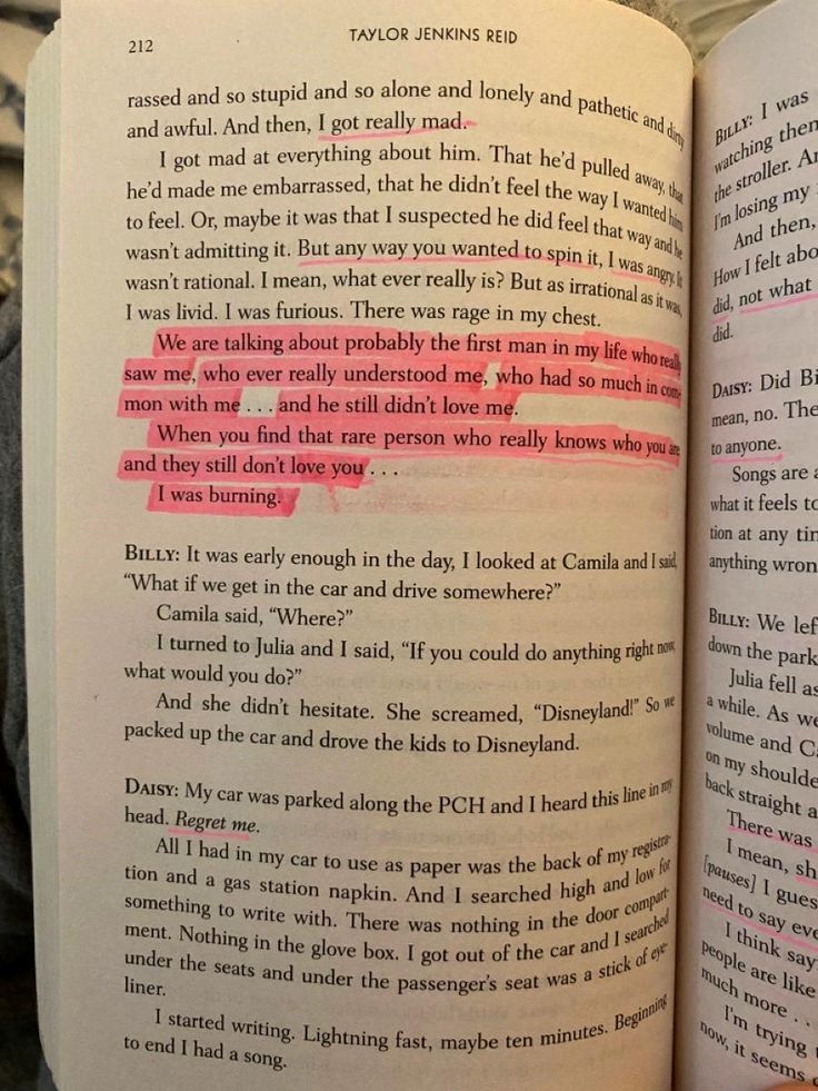 an open book with pink writing on the page and someone's hand holding it