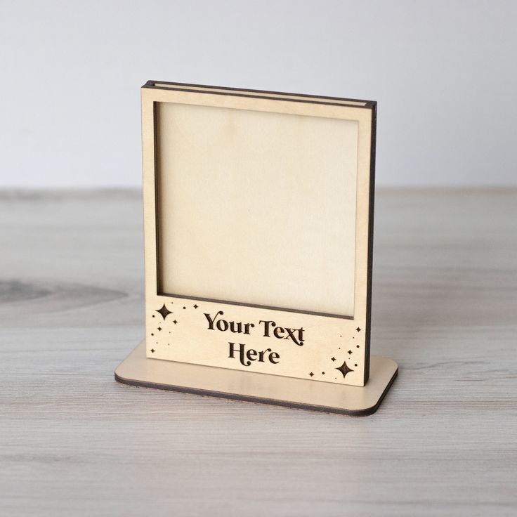 a wooden photo frame on a table with a white wall behind it and the words your text here