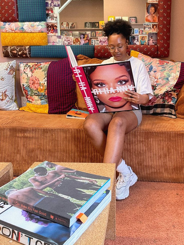 a woman sitting on a couch reading a book