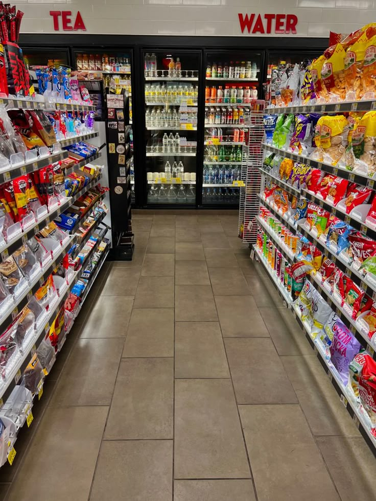 a grocery store aisle with shelves full of food and drinks on the shelves, as well as water