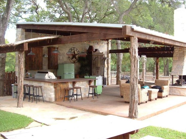 an outdoor kitchen is built into the side of a building with bars and stools