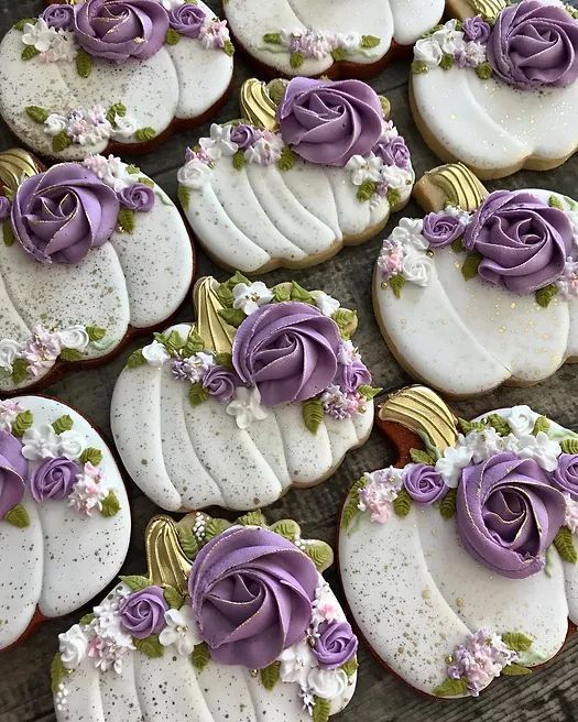 there are many decorated cookies with purple flowers on them and gold trim around the edges