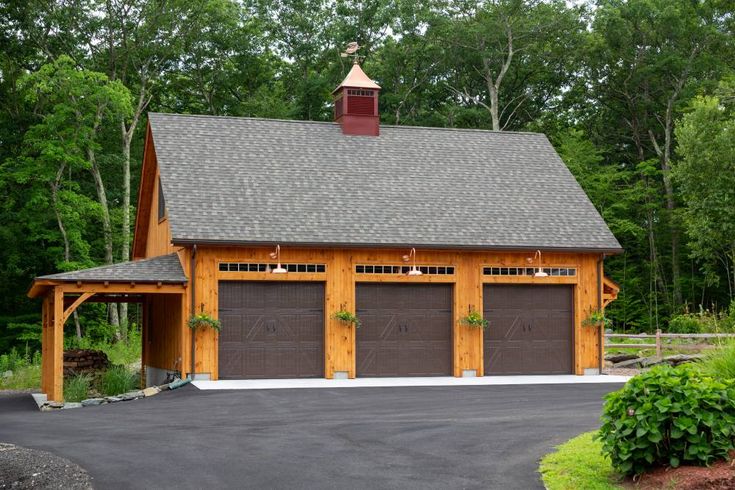 a two car garage with three doors and a steeple on the top of it