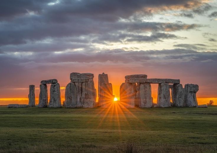 the sun is setting over stonehenge in england