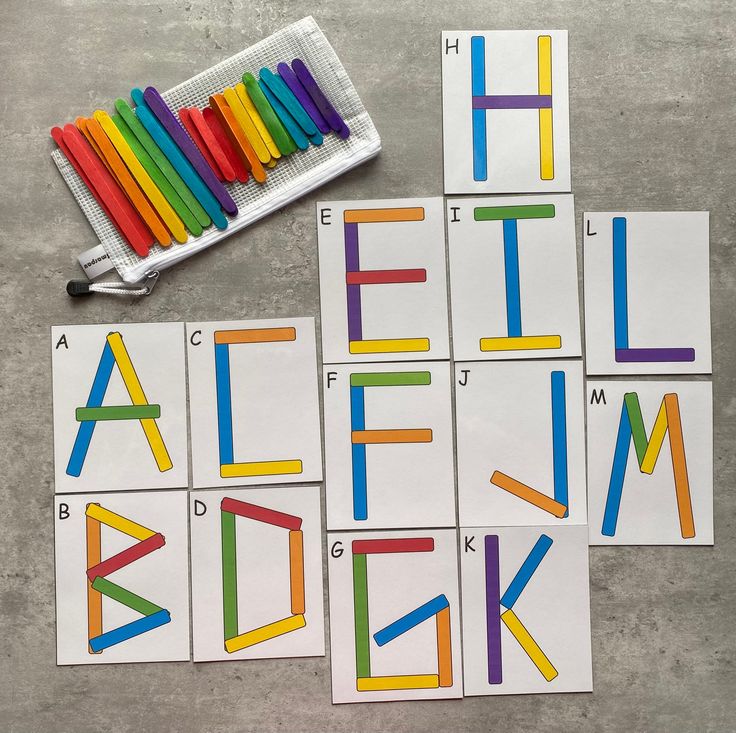 colorful alphabets and crayons are laid out on the floor next to markers