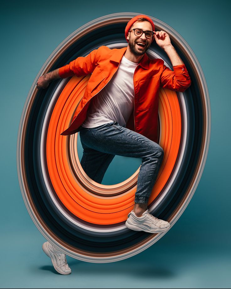 a man in an orange jacket is posing for the camera with his hands behind his head