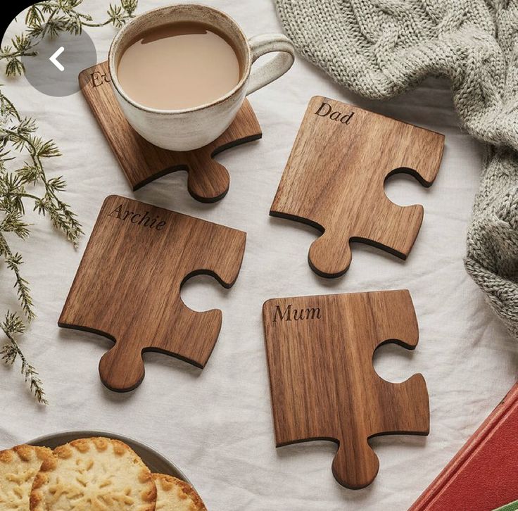 four personalized wooden puzzles on a table next to a cup of coffee and crackers