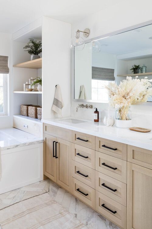 a bathroom with a tub, sink and large mirror above it's counter top