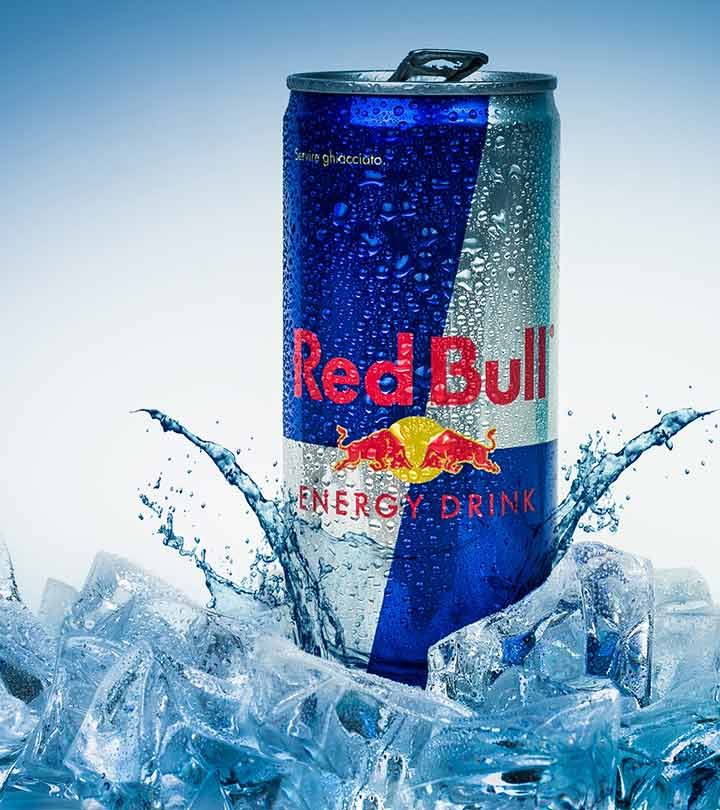 a can of red bull energy drink is splashing in the water with ice cubes around it