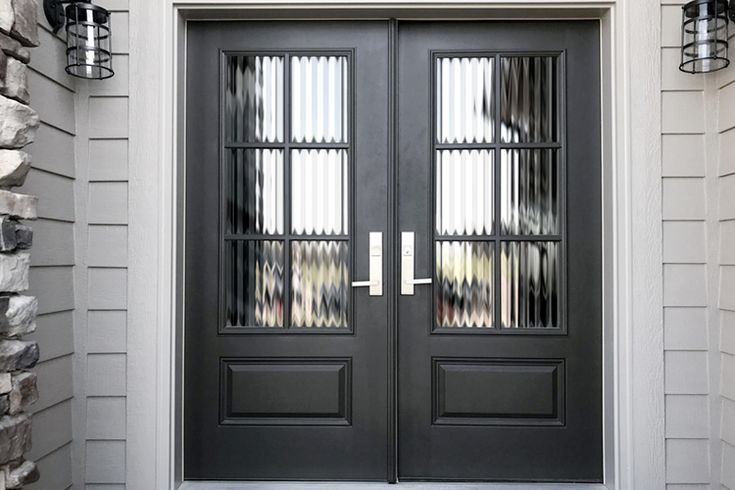 a black double door with two sidelights on the front of a house and brick wall behind it