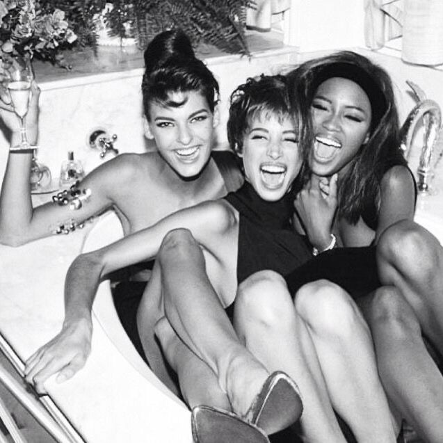 three women sitting in a bathtub with their arms around each other