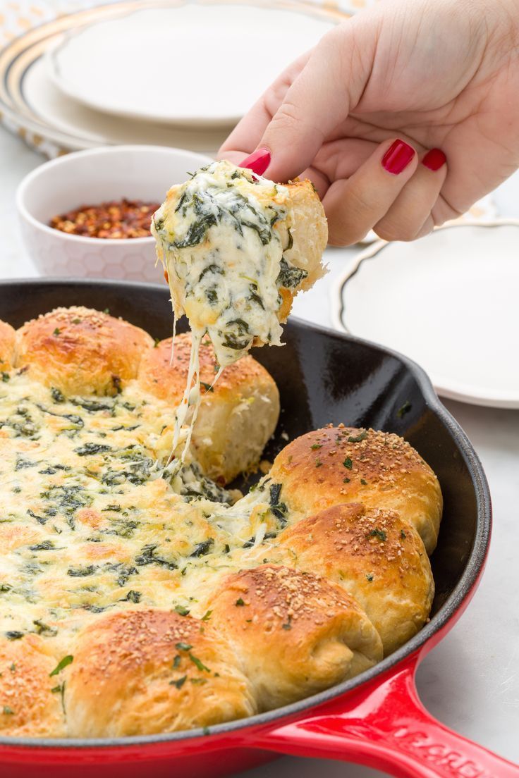 a person dipping cheese onto bread in a skillet