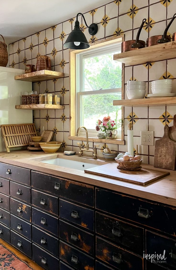 an old fashioned kitchen with lots of drawers and shelves on the wall above the sink