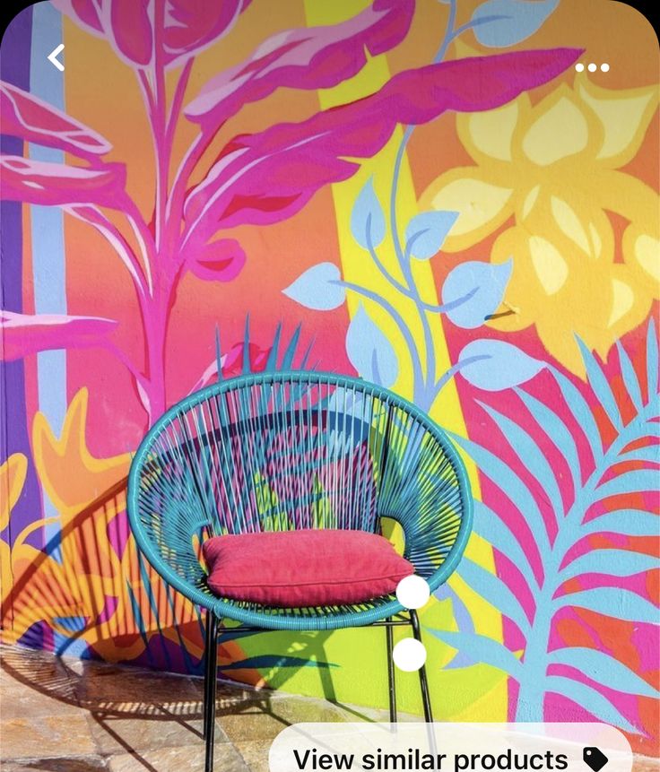 a blue chair sitting in front of a colorful wall