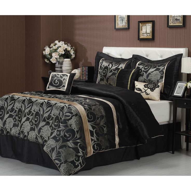 black and gold bedding with white pillows in a brown room next to a table