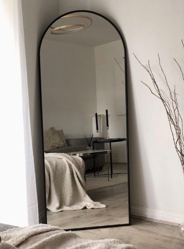 a large mirror sitting on top of a wooden floor