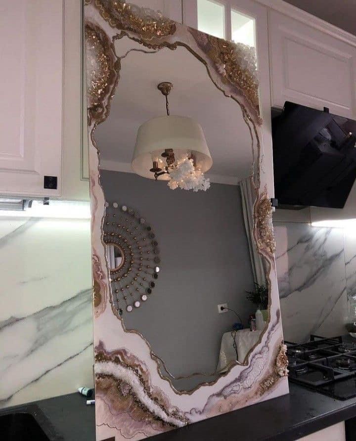 a mirror that is on the side of a wall in front of a stove top