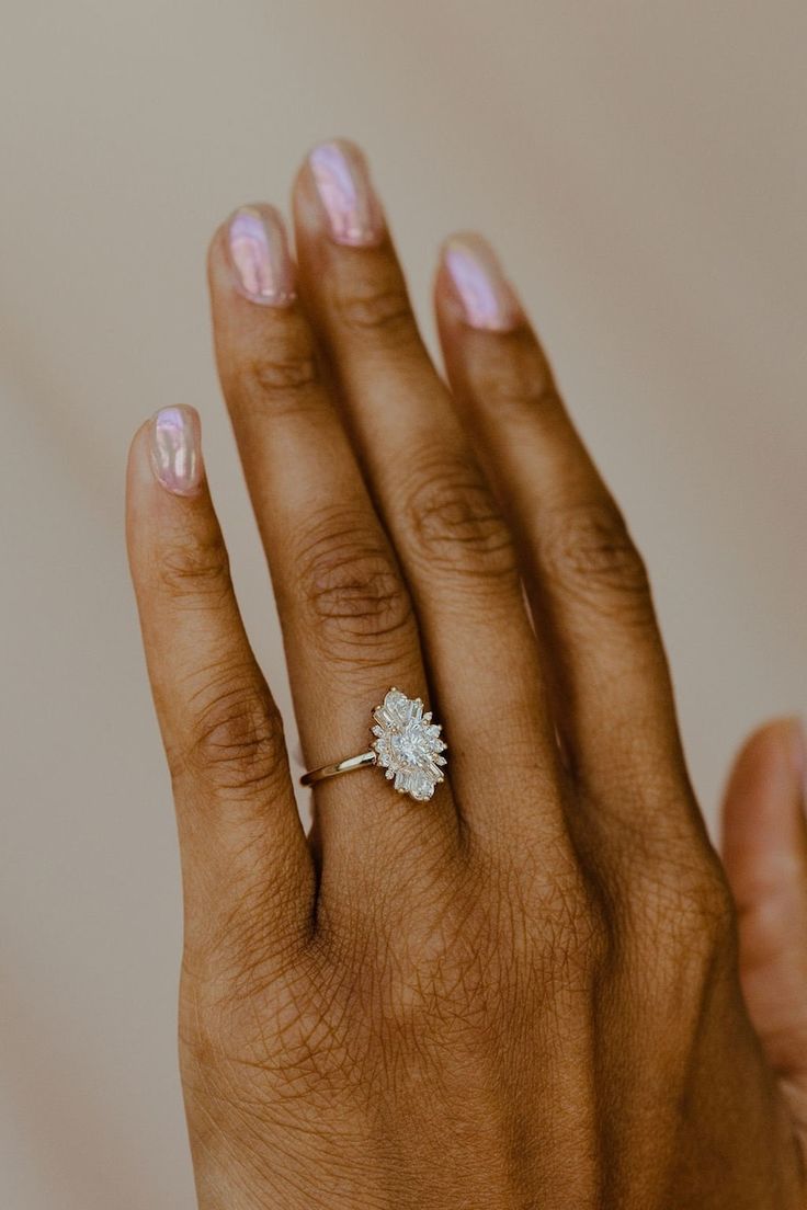 a woman's hand with a diamond ring on it