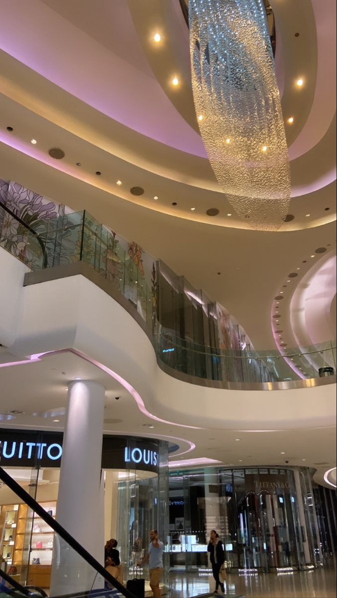 the interior of a luxury shopping mall with chandelier