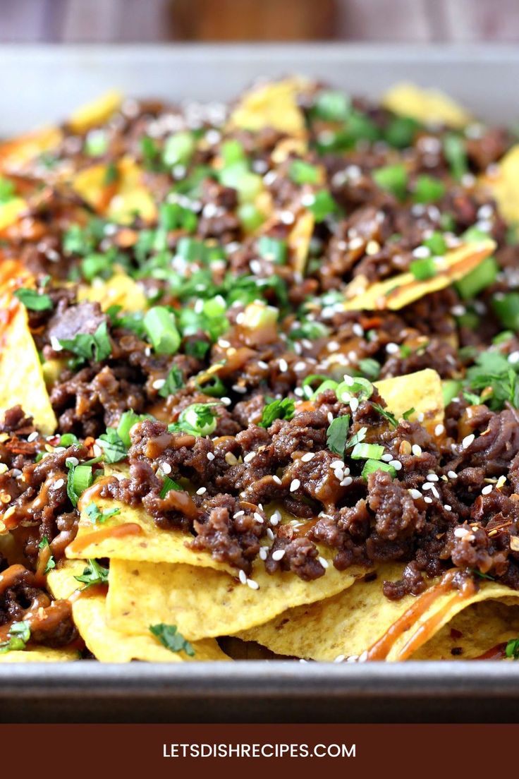 nachos topped with ground beef and green onions