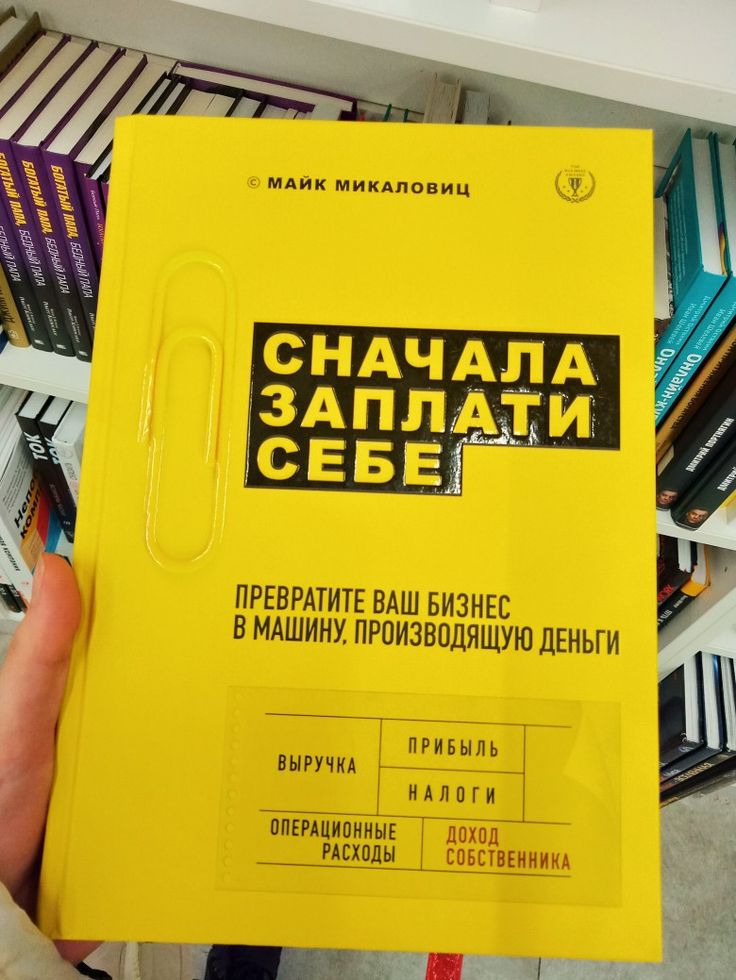 a person holding up a yellow book in their hand