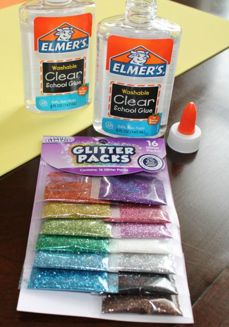 two bottles of clear glue sitting on top of a table next to each other with different colors