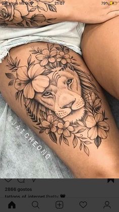 a woman's thigh with a lion and flowers on the side, next to her stomach