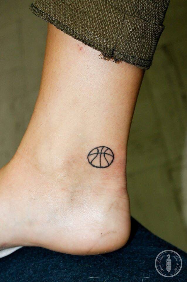 a small tattoo on the ankle of a person with a basketball ball in it's center