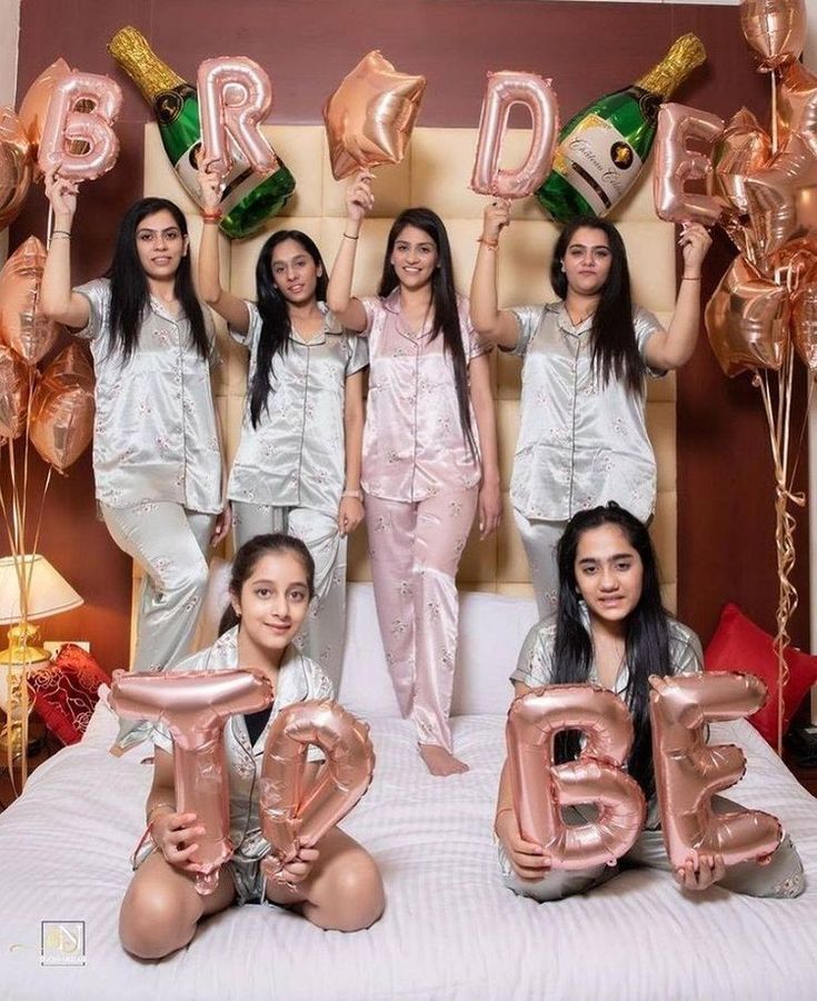 the girls are posing with their balloons in front of them and holding up letters that spell out the word bride