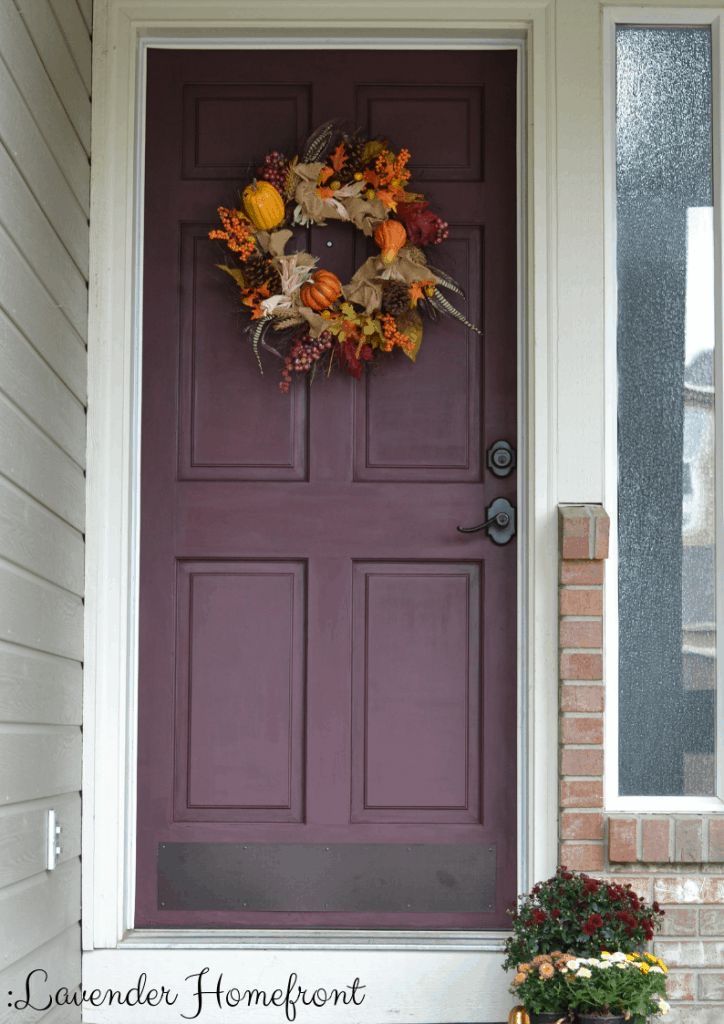 a purple front door with a wreath on it