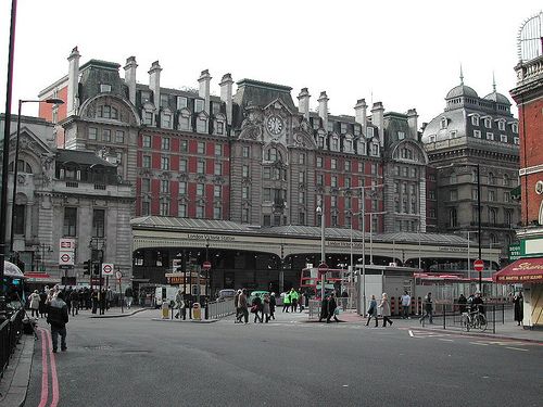 people are walking on the street in front of an old building