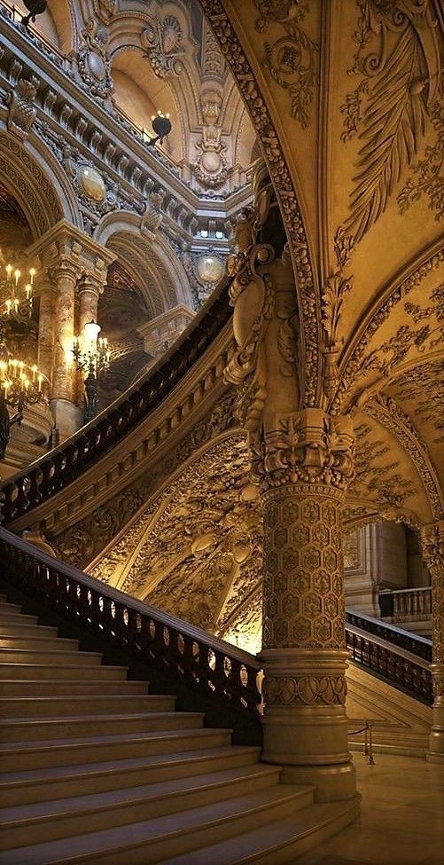 an ornate staircase with chandeliers in a building