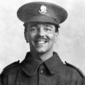 black and white photograph of a man in uniform smiling for the camera with his hat on