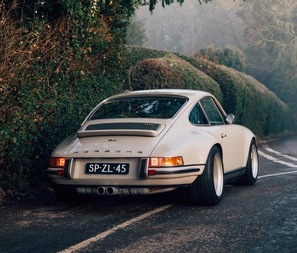 a white porsche parked on the side of a road