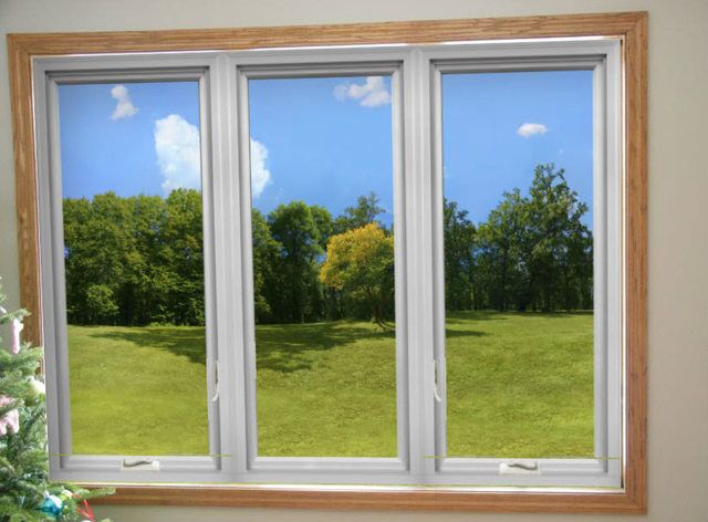 an open window in a room with a christmas tree and green field outside the window