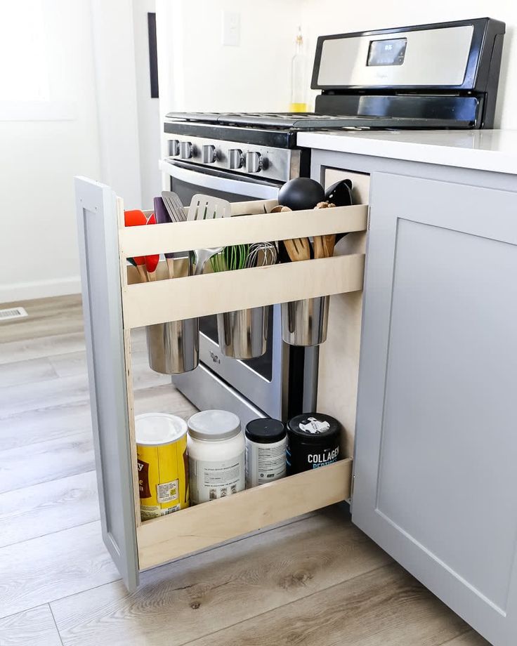 an open drawer in the middle of a kitchen