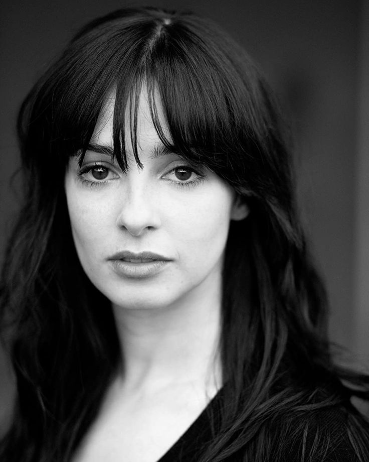 a black and white photo of a woman with long hair looking at the camera,