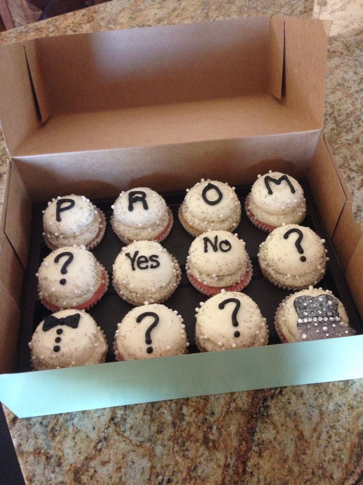 a box filled with cupcakes covered in frosting that say prom and yes