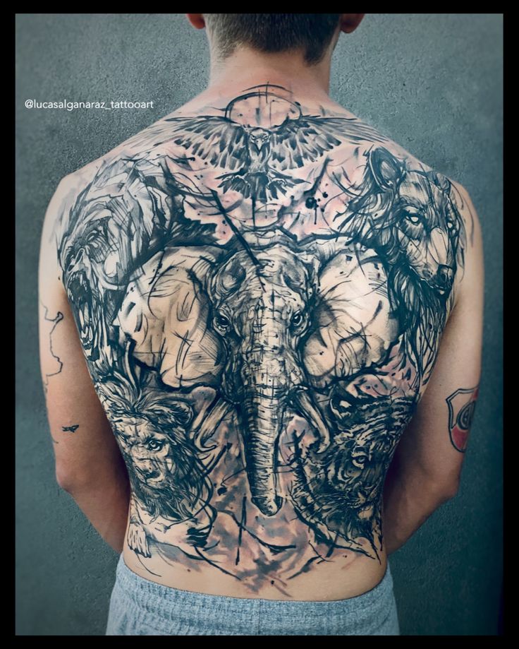 the back of a man with tattoos on his body and an elephant in the middle