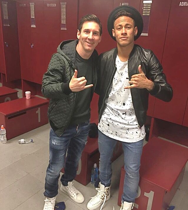 two young men standing next to each other in a locker room with red lockers